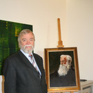Redner Manfred A. Getzner mit dem Porträt von Pfarrer Josef Häusle. 