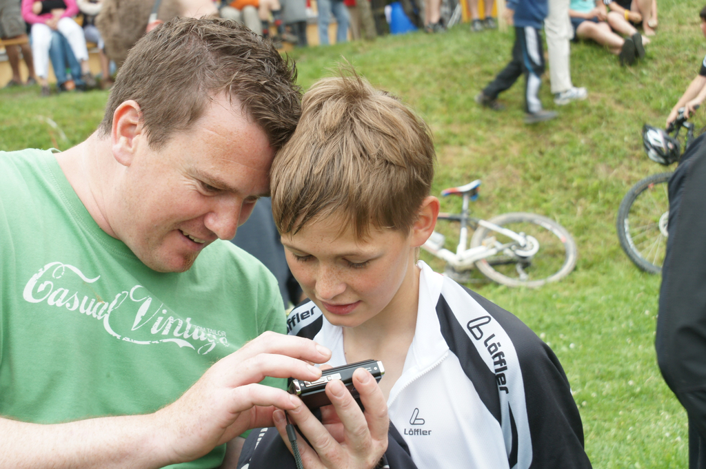 Schoppernau Triathlon  Hubert zeigt  Otto  den  Zieleinlauf  auf Handy .jpg