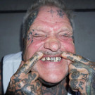 Anmerkung der Redaktion: Bei dem Tattoo oberhalb des rechten Mittelfingers handelt es sich um ein Swastika. Mit der leicht gesch