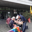 Aktivisten kleben sich vor Landhaus an Tisch