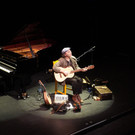 Ein Straßenmusiker auf der großen Theaterbühne