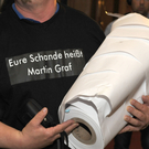 Grüne rollen meterlangen Unterschriftenteppich gegen Graf aus 