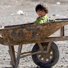 Kind sitzt in einer Scheibtruhe in Kandahar, Afghanistan.
