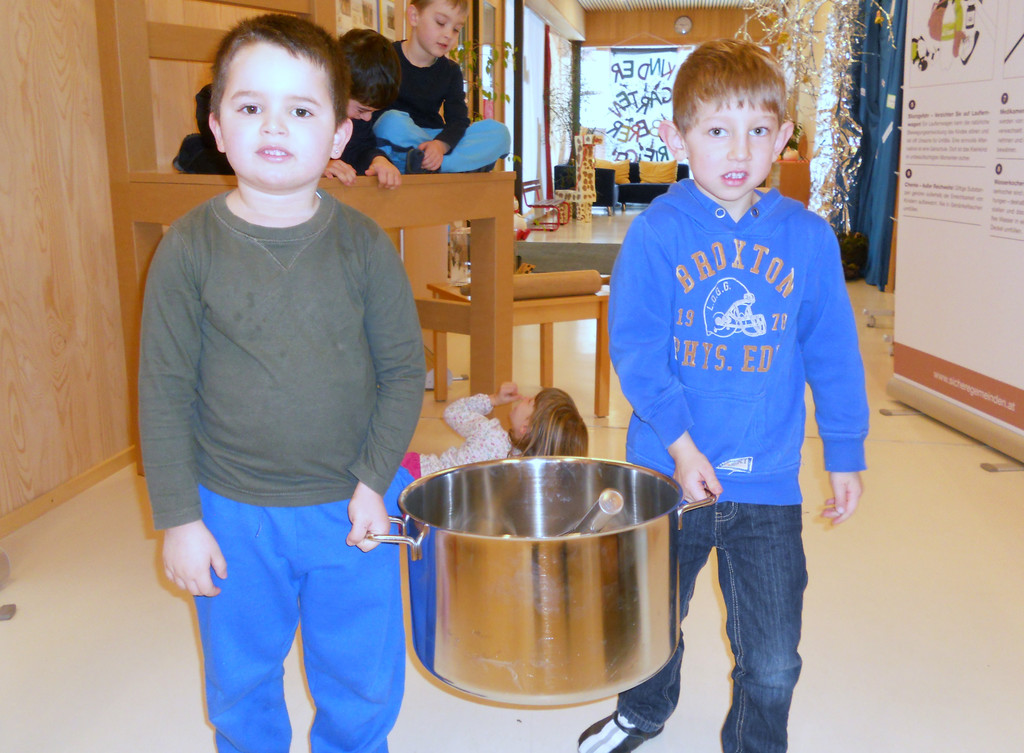 07 Emilio und Felix heben den schweren Kochtopf.JPG