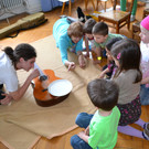 31 Die Kinder sehen die Schwingungen mithilfe eines Wassertellers auf der Gitarre.JPG